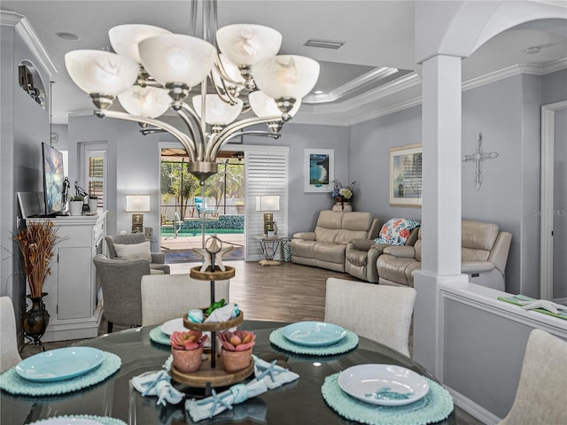 2908 89th Ave E, Parrish, FL 34219 - dining space with a chandelier, crown molding, wood finished floors, and ornate columns