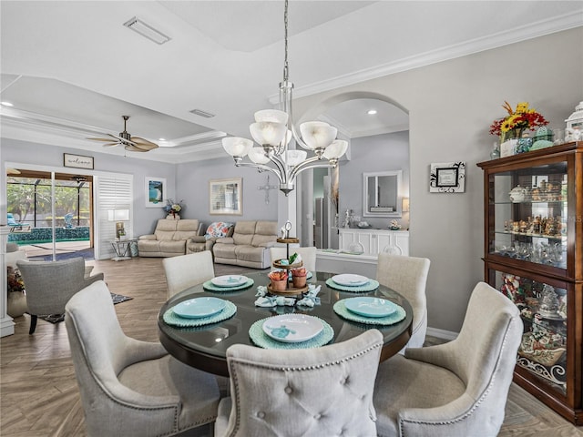 2908 89th Ave E, Parrish, FL 34219 - dining area with a raised ceiling, a chandelier, crown molding, a ceiling fan, and arched walkways