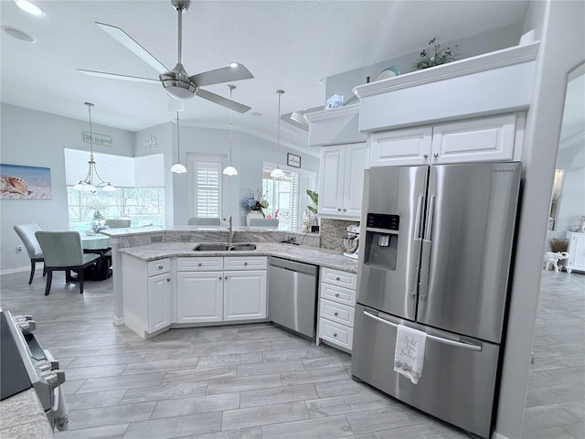 2908 89th Ave E, Parrish, FL 34219 - kitchen featuring appliances with stainless steel finishes, a sink, a peninsula, ceiling fan, and white cabinets