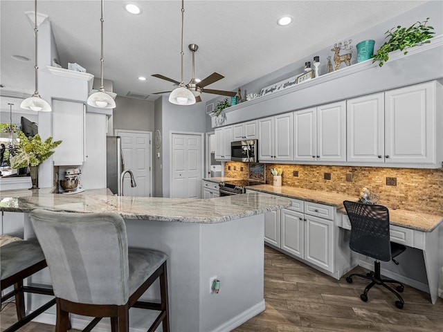 2908 89th Ave E, Parrish, FL 34219 - kitchen with appliances with stainless steel finishes, white cabinetry, a peninsula, ceiling fan, and tasteful backsplash