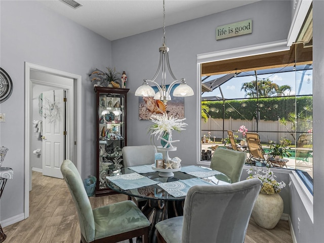 2908 89th Ave E, Parrish, FL 34219 - dining space featuring wood finished floors, baseboards, and a chandelier