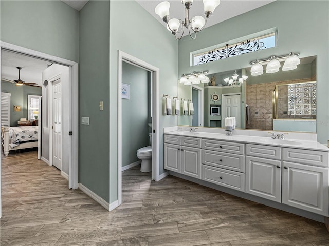 2908 89th Ave E, Parrish, FL 34219 - ensuite bathroom featuring a chandelier, double vanity, toilet, tiled shower, and a ceiling fan