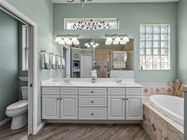 2908 89th Ave E, Parrish, FL 34219 - bathroom with a chandelier, toilet, a tile shower, double vanity, and a bath