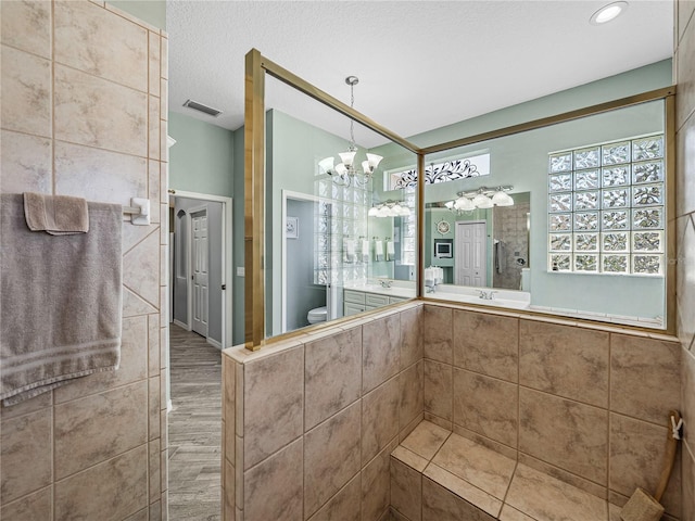 2908 89th Ave E, Parrish, FL 34219 - full bath with toilet, vanity, a chandelier, wood finished floors, and a textured ceiling