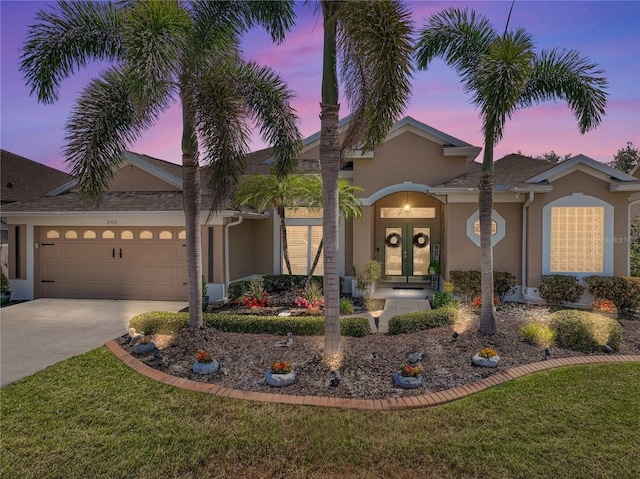 2908 89th Ave E, Parrish, FL 34219 - view of front of home featuring stucco siding, french doors, an attached garage, and driveway