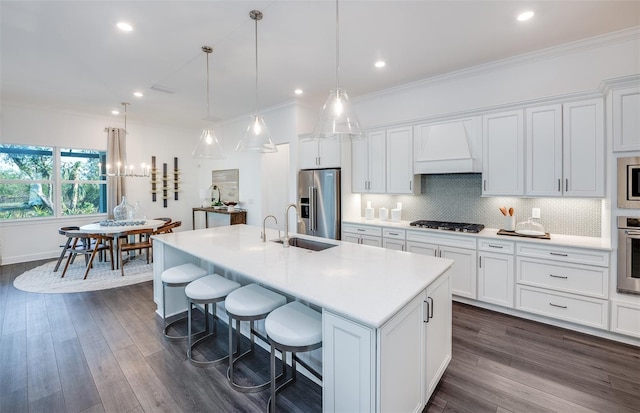 14727 Eagle Branch Dr, Nokomis, FL 34275 - kitchen with white cabinets, appliances with stainless steel finishes, a sink, a kitchen island with sink, and custom exhaust hood