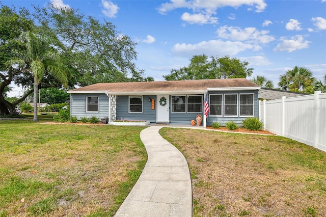view of front of house featuring fence and a front lawn