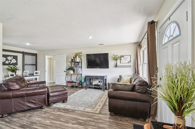 living room with plenty of natural light, recessed lighting, a textured ceiling, and wood finished floors