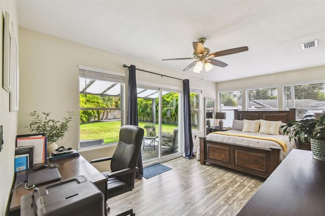 bedroom featuring visible vents, light wood-style flooring, ceiling fan, and access to outside