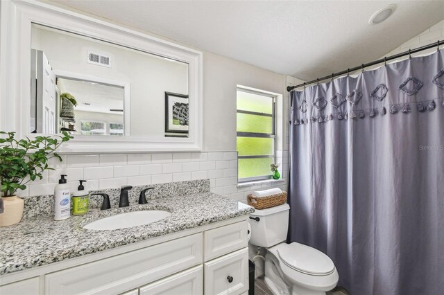 bathroom featuring visible vents, vanity, toilet, a shower with curtain, and backsplash