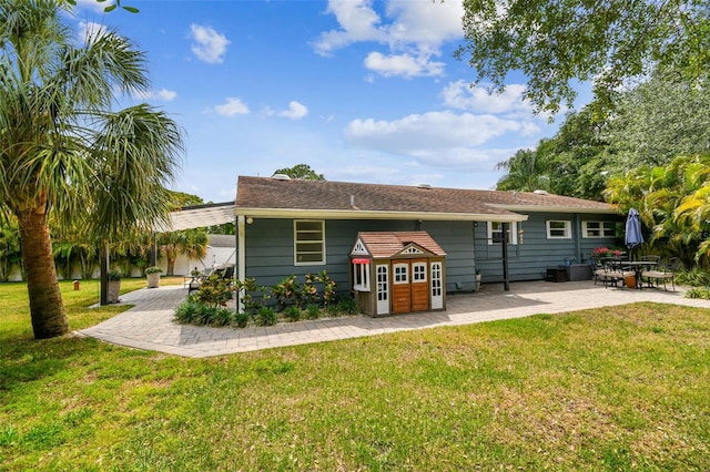 rear view of house with a yard and a patio area