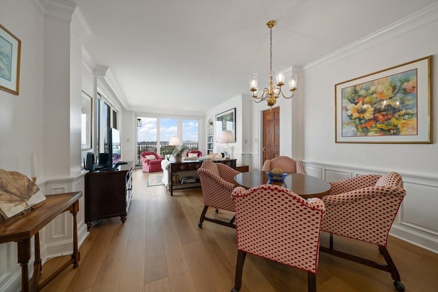 4 Belleview Blvd Unit 802, Belleair, FL 33756 - dining room featuring crown molding, light wood-style flooring, a decorative wall, and an inviting chandelier