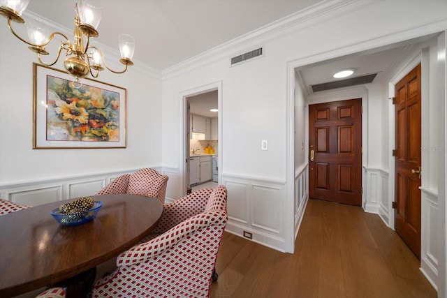 4 Belleview Blvd Unit 802, Belleair, FL 33756 - dining room with crown molding, wood finished floors, a decorative wall, a wainscoted wall, and a notable chandelier