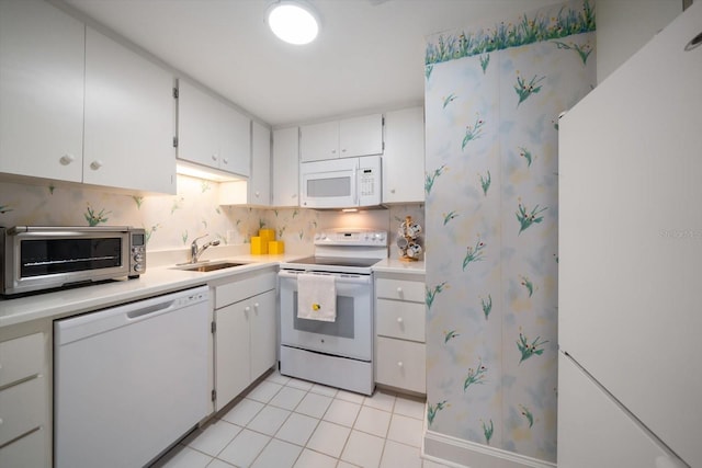 4 Belleview Blvd Unit 802, Belleair, FL 33756 - kitchen featuring white cabinets, a sink, white appliances, light countertops, and decorative backsplash