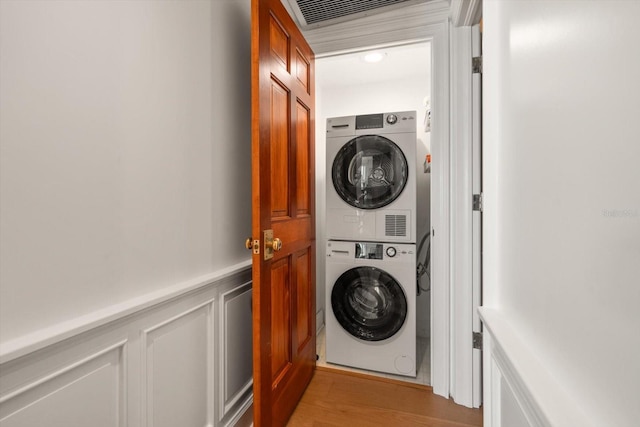 4 Belleview Blvd Unit 802, Belleair, FL 33756 - clothes washing area with laundry area, wainscoting, a decorative wall, light wood-style floors, and stacked washer / dryer