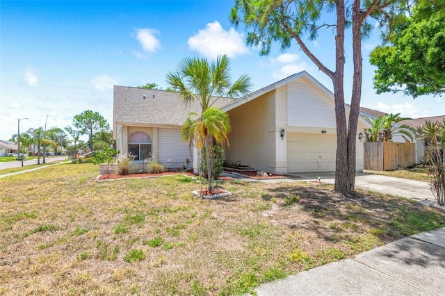 ranch-style house with fence, an attached garage, driveway, and a front lawn