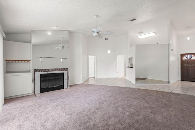 unfurnished living room featuring a ceiling fan, a textured ceiling, light colored carpet, light tile patterned floors, and high vaulted ceiling