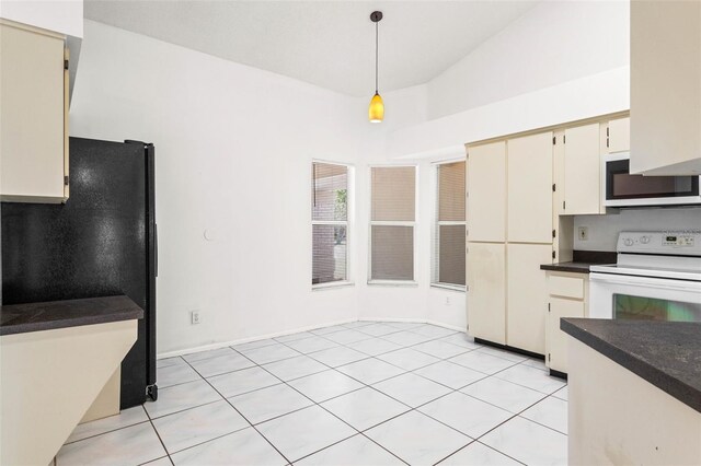kitchen with freestanding refrigerator, pendant lighting, dark countertops, white electric stove, and light tile patterned floors