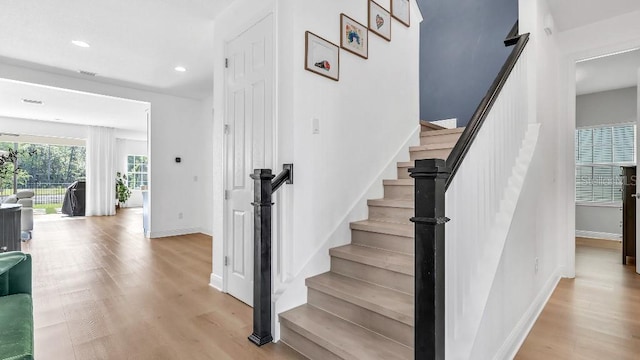 stairway featuring baseboards, recessed lighting, and wood finished floors