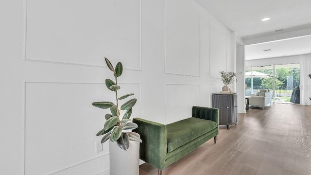 corridor featuring recessed lighting, wood finished floors, and a decorative wall