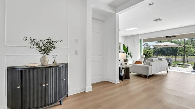 interior space featuring light wood-type flooring, baseboards, and visible vents