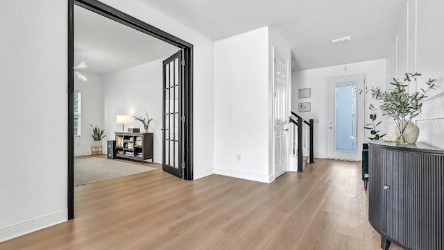 hall with baseboards and light wood-type flooring