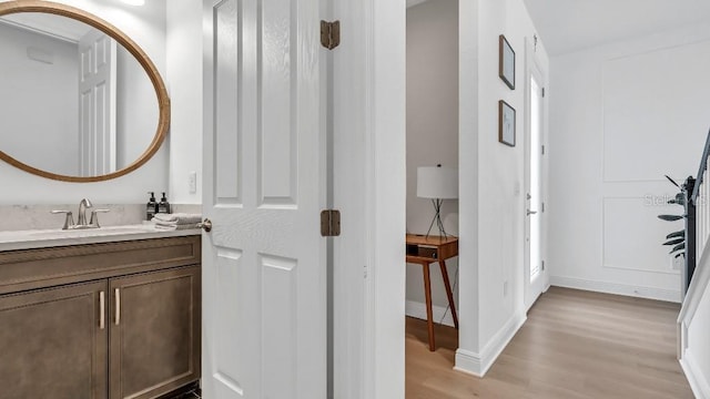 bathroom featuring vanity, baseboards, and wood finished floors