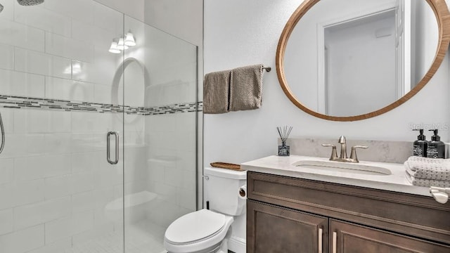 bathroom with vanity, a stall shower, and toilet
