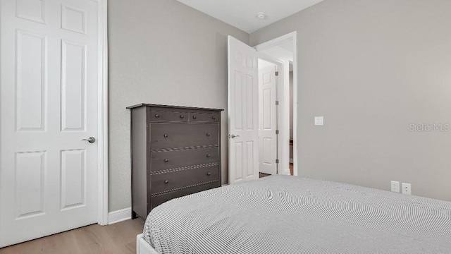 bedroom with baseboards and light wood-type flooring