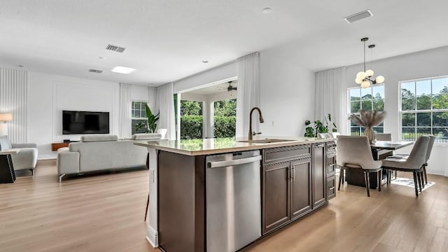 kitchen featuring stainless steel dishwasher, visible vents, a sink, and light wood-style flooring