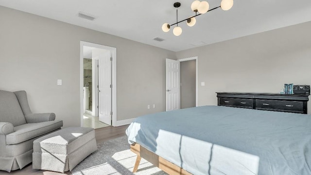 bedroom with baseboards, wood finished floors, and visible vents