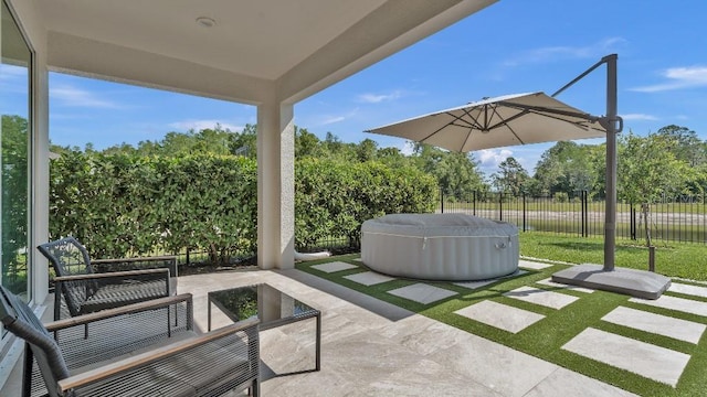 view of patio featuring fence and a hot tub