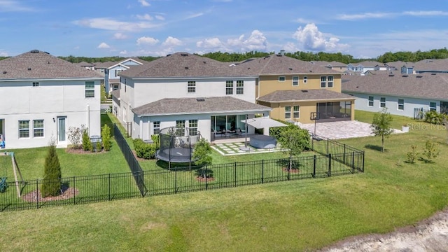 back of property featuring a patio, a fenced backyard, a lawn, a trampoline, and a residential view