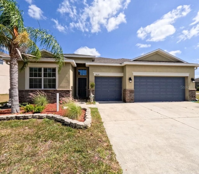 prairie-style home with an attached garage, stone siding, and stucco siding