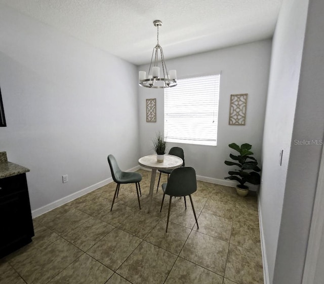 dining space with an inviting chandelier, baseboards, and dark tile patterned flooring