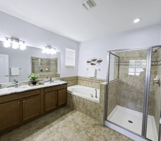 bathroom with a sink, double vanity, a shower stall, visible vents, and a bath