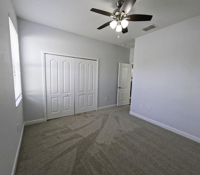 unfurnished bedroom featuring a ceiling fan, visible vents, baseboards, a closet, and carpet flooring