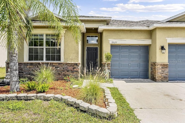 18677 Milton Keynes Ct, Land O Lakes, FL 34638 - entrance to property featuring stone siding, stucco siding, and concrete driveway