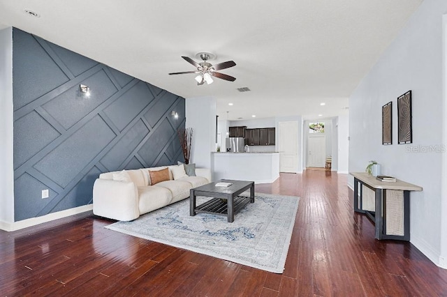 18677 Milton Keynes Ct, Land O Lakes, FL 34638 - living area featuring a decorative wall, baseboards, a ceiling fan, and dark wood-style flooring