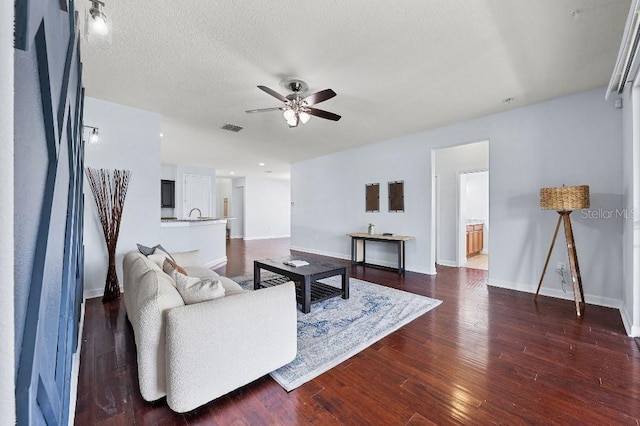 18677 Milton Keynes Ct, Land O Lakes, FL 34638 - living area with a ceiling fan, dark wood-style flooring, baseboards, and a textured ceiling