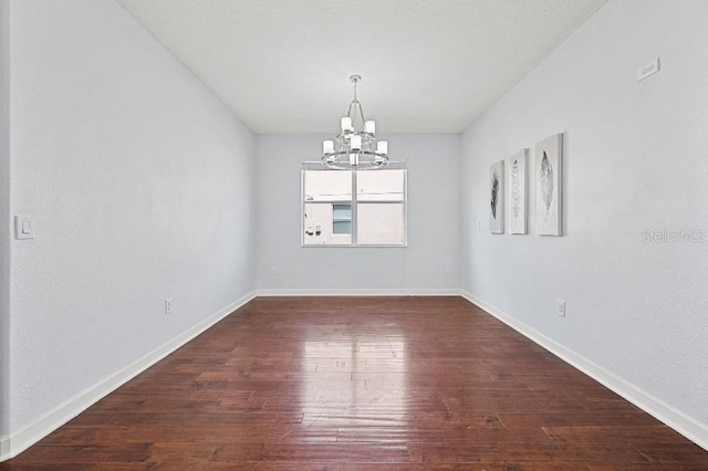 18677 Milton Keynes Ct, Land O Lakes, FL 34638 - empty room with a chandelier, hardwood / wood-style flooring, and baseboards