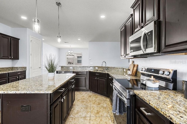 18677 Milton Keynes Ct, Land O Lakes, FL 34638 - kitchen with stainless steel appliances, a sink, light stone counters, pendant lighting, and recessed lighting