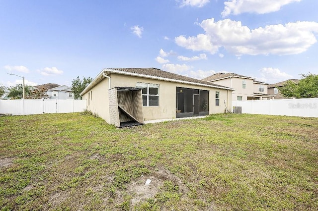 18677 Milton Keynes Ct, Land O Lakes, FL 34638 - rear view of house with stucco siding, central AC, and a sunroom