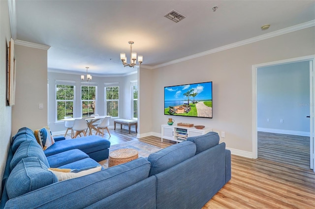 living room featuring crown molding, baseboards, a chandelier, and light wood finished floors