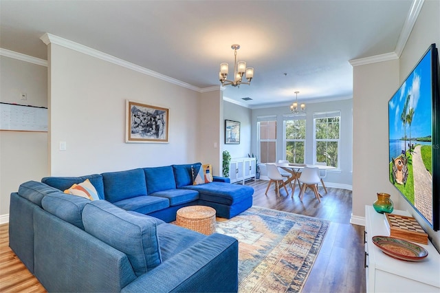 living room with baseboards, an inviting chandelier, ornamental molding, and wood finished floors