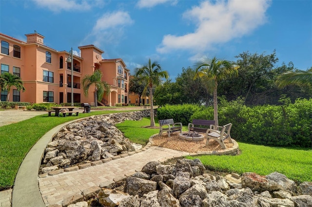 view of property's community featuring a fire pit and a yard