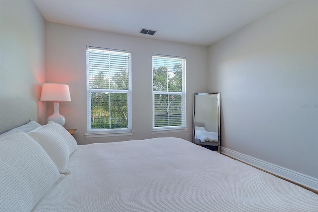 bedroom with baseboards and visible vents