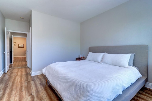 bedroom featuring baseboards and wood finished floors