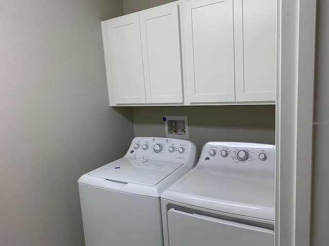 clothes washing area featuring cabinet space and washing machine and dryer
