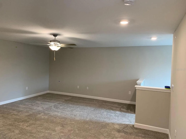 carpeted empty room with baseboards and a ceiling fan